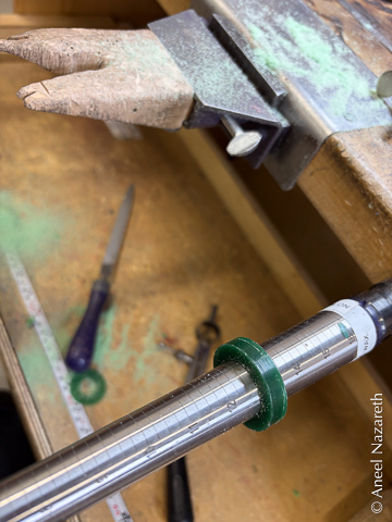 A square profile wax ring is on a ring sizing mandrel. It's around a size 13